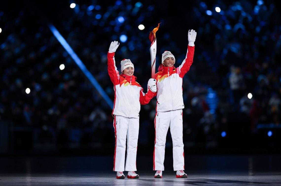 Dinigeer Yilamujiang (l) und Zhao Jiawen mit der Olympischen Fackel bei der Eröffnungsfeier.