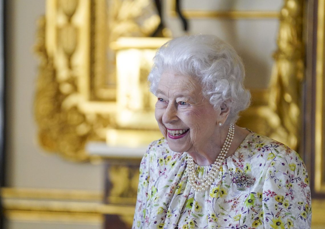 Die britische Königin Elizabeth II. lächelt, als sie im White Drawing Room von Schloss Windsor eine Ausstellung von Artefakten des britischen Kunsthandwerksunternehmens Halcyon Days besichtigt.